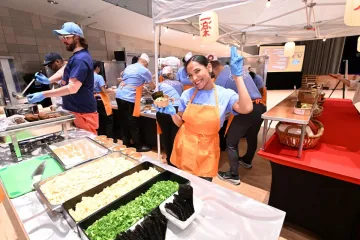 staff holding ramen bowl