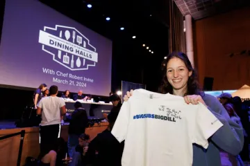 A student holding a shirt signed by Chef Mike
