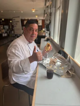 Chef Mike eating the sub and giving a thumbs up