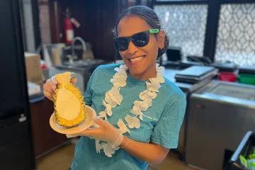 A staff member holding a sorbet-filled pineapple