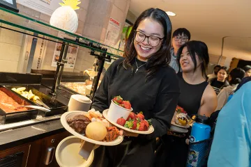 A student carrying a plate of food at Ferris
