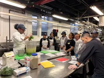Apprentice Chef de Cuisine Devante Dickerson walks staff through a recipe for a pesto