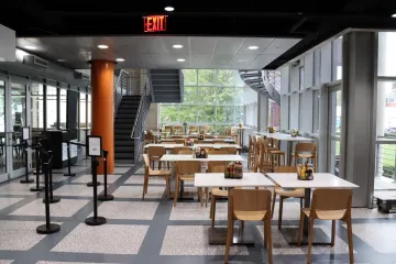 Ferris Booth Commons seating area featuring new white tables with light wood chairs