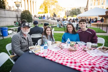 family sitting on the lawn with their food