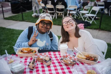 two students smiling while they eat 