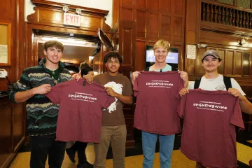 students holding up the tee shirts