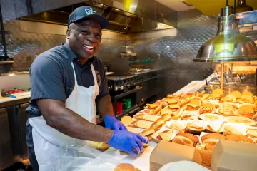 Dining employee making burgers at JJ's Place.