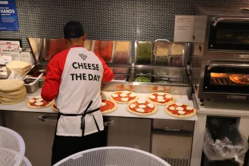 Chef Don's Pizza Pi staff member making pizzas behind the counter