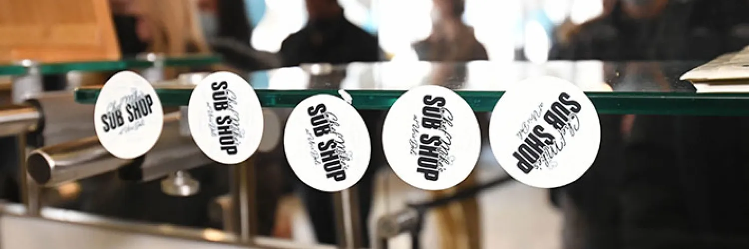 Branding Stickers at Chef Mike’s Sub Shop, students out of focus in the background waiting for lunch.