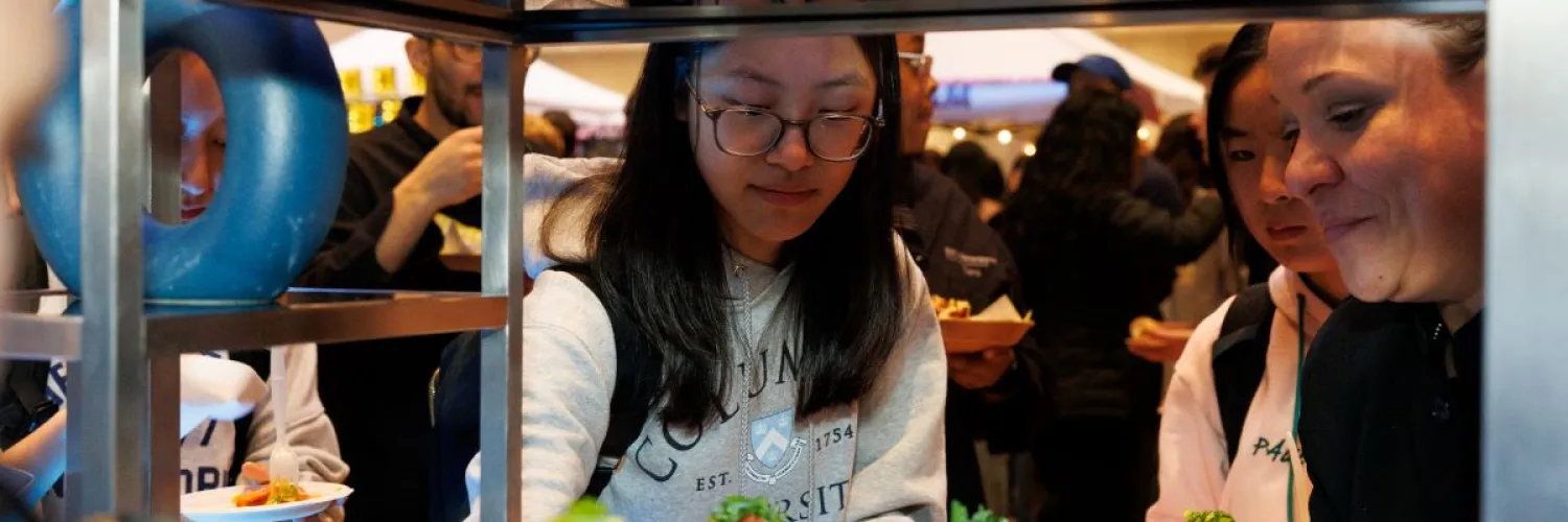 Students take food from the Faculty House tent