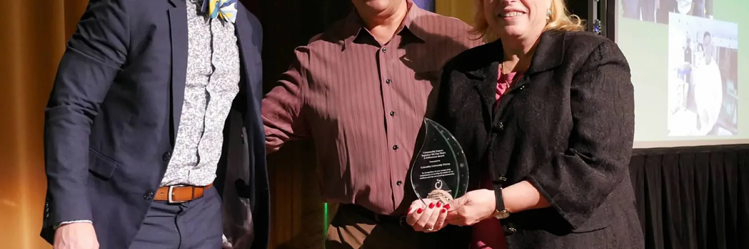 Joseph Greenwell, Michael DeMartino, and Vicki Dunn. Vicki is holding the award.